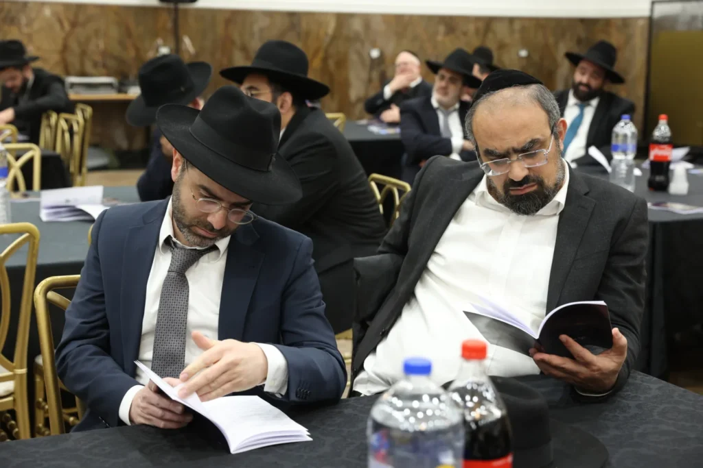 משתתפי הועידה מעיינים בחוברת